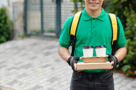 Téléchargez les photos : Courrier livrant pizza, café et dessert au client - en image libre de droit