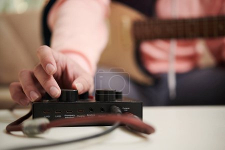 Téléchargez les photos : Mains de musicien utilisant un amplificateur pour régler le niveau de volume - en image libre de droit