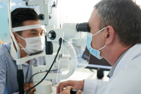 Photo for Ophthalmologist checking eyes of patient for eye disesases - Royalty Free Image