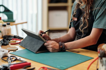 Téléchargez les photos : Mains de talentueuse jeune femme dessin croquis de sac sur tablette numérique - en image libre de droit