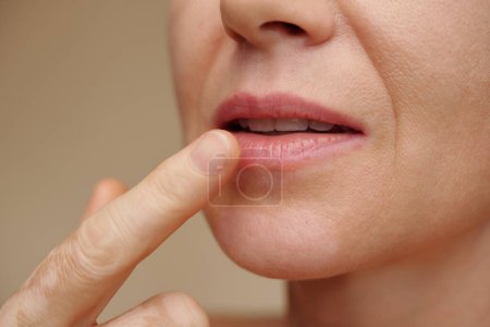 Foto de Mujer de mediana edad que aplica tratamiento hidratante en los labios - Imagen libre de derechos
