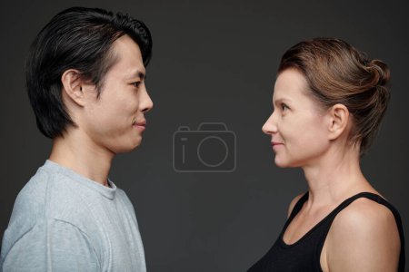 Téléchargez les photos : Homme et femme debout sur fond gris et se regardant - en image libre de droit