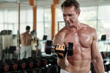 Photo for Sweaty shirtless sportsman doing exercise with dumbbells - Royalty Free Image