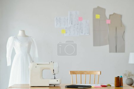 Photo for Desk of seamstress with sewing machine and planner in studio - Royalty Free Image