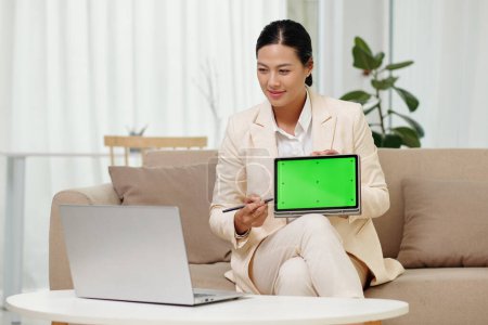 Foto de Mujer de negocios sonriente que muestra la presenación en el ordenador tableta a los colegas en la reunión en línea - Imagen libre de derechos