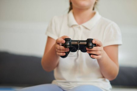Foto de Chica con controlador en las manos jugando videojuego en casa - Imagen libre de derechos