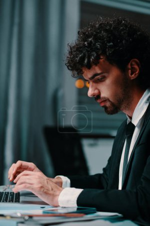 Photo for Serious entrepreneur working on latop in dark office late at night - Royalty Free Image