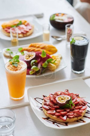 Téléchargez les photos : Tartelette aux fruits, smoothies et fraises sur la table du restaurant - en image libre de droit