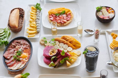 Téléchargez les photos : Viande cuite, gaufres aux fruits et bol de musli sur la table du petit déjeuner dans le café - en image libre de droit