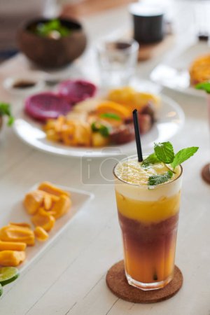 Téléchargez les photos : Grand verre de boisson froide décoré avec des feuilles de menthe sur la table de brunch - en image libre de droit