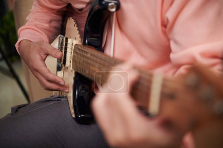 Téléchargez les photos : Image rapprochée du musicien jouant de la guitare practivant une nouvelle chanson - en image libre de droit