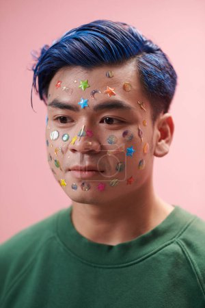 Photo for Portrait of teenage boy with blue hair and bright stickers on face - Royalty Free Image