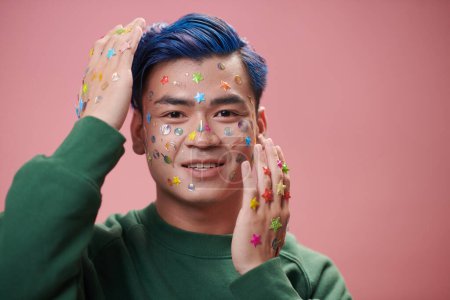 Photo for Portrait of joyful young man with stickers on face and hands - Royalty Free Image