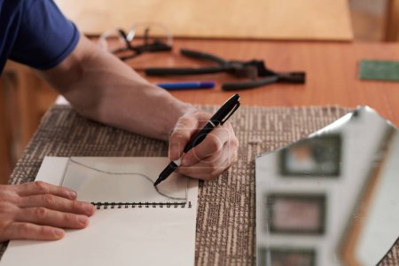 Téléchargez les photos : Esquisses de dessin d'artisan gaucher pour un nouveau projet de verre - en image libre de droit