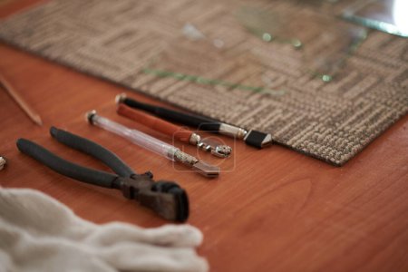 Téléchargez les photos : Différentes coupeurs de verre et pinces sur la table dans l'atelier de verrier - en image libre de droit