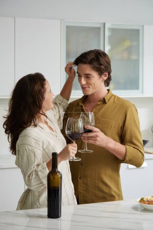 Foto de Feliz novio y novia mirándose con amor y afecto cuando beben vino - Imagen libre de derechos