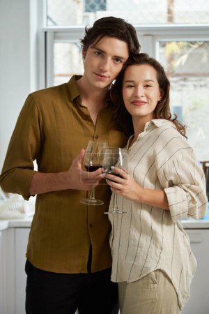 Photo for Portrait of happy couple in love drinking wine and hugging each other - Royalty Free Image