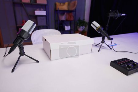 Téléchargez les photos : Deux microphones et une boîte blanche sur la table dans le studio du blogueur beauté - en image libre de droit