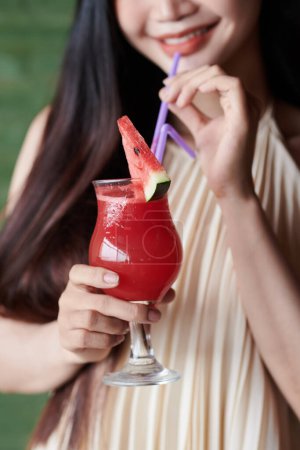 Téléchargez les photos : Image recadrée d'une jeune femme sirotant un cocktail de pastèque rafraîchissant - en image libre de droit