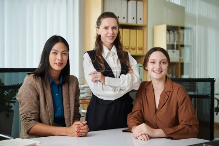 Photo for Portrait of team of businesswomen smiling at camera while working together in office - Royalty Free Image