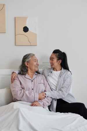 Téléchargez les photos : Femme gaie rendant visite à sa mère âgée dans une maison de retraite - en image libre de droit