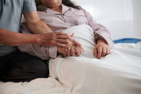 Téléchargez les photos : Mari tenant la main de la femme malade pour la soutenir - en image libre de droit
