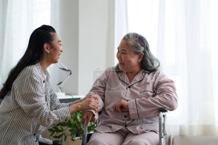 Foto de Cuidador alegre visitando a una mujer mayor en un hogar de ancianos para entretenerla - Imagen libre de derechos