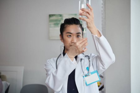 Foto de Médico agregando medicamento al contador de gotas para el paciente - Imagen libre de derechos