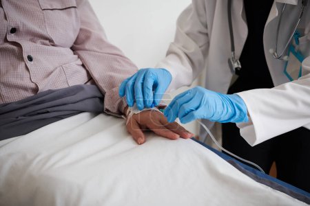 Photo for Closep image of doctor in medical gloves inserting IV catheter - Royalty Free Image