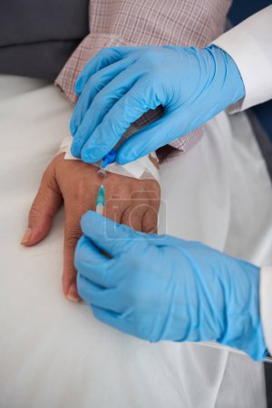 Photo for Hands of doctor removing intravenous catheter after finishing medical procedure - Royalty Free Image