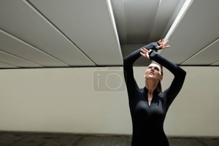 Foto de Bailarina urbana creativa inspirada haciendo movimientos de mano en los rayos del sol - Imagen libre de derechos