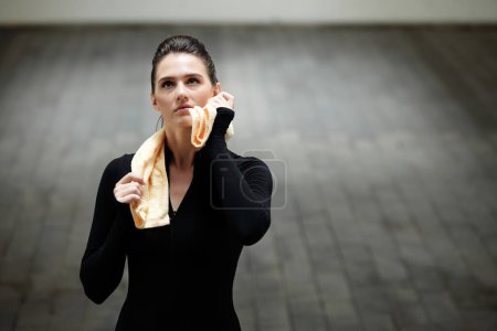 Foto de Retrato de una joven deportista cansada limpiando el sudor con una toalla después de trotar o hacer ejercicio - Imagen libre de derechos