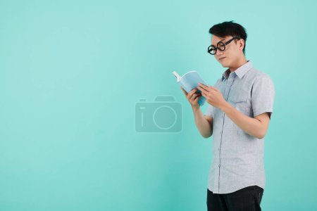 Foto de Joven inteligente en gafas con lentes gruesas libro de lectura - Imagen libre de derechos