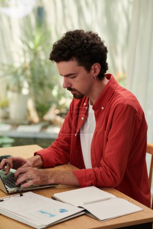Foto de Startupper trabajando en el ordenador portátil al analizar los informes después de lanzar el primer proyecto - Imagen libre de derechos