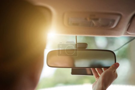 Photo for Driver fixing rearview mirror when driving car to work - Royalty Free Image