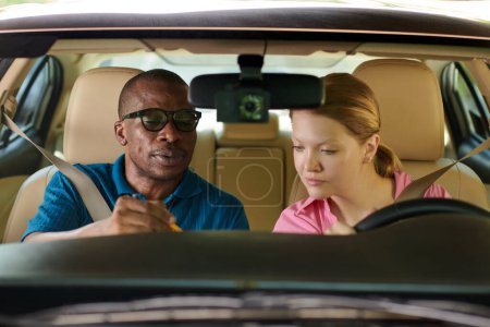 Photo for Driving instructor explaining student how driving exam will be evaluated - Royalty Free Image