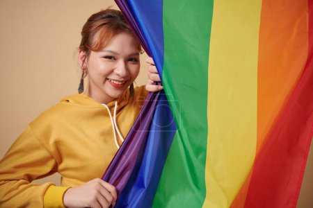 Foto de Retrato de mujer transgénero feliz de pie junto a la bandera de rayas lgbt - Imagen libre de derechos