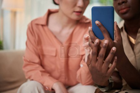 Foto de Imagen de primer plano de la mujer negra mostrando amigo nuevo mercado aplicación móvil - Imagen libre de derechos