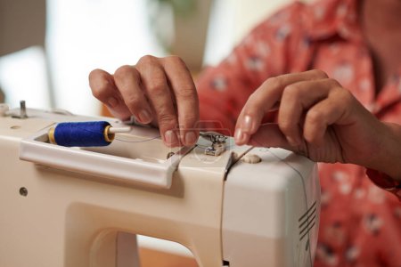 Photo for Closeup image of seamstress preparing sewing machine for work - Royalty Free Image