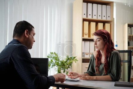 Photo for Young businesswoman telling colleague her creative ideas in meeting - Royalty Free Image
