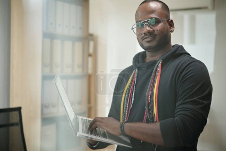 Téléchargez les photos : Portrait de développeur de logiciels dans la programmation à capuche sur ordinateur portable - en image libre de droit