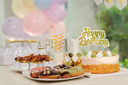 Téléchargez les photos : Gâteau d'anniversaire décoré, beignets et cupcakes sur la table préparés pour les invités - en image libre de droit