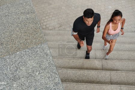 Foto de Ajuste pareja joven corriendo escaleras arriba cuando se entrena para maratón - Imagen libre de derechos