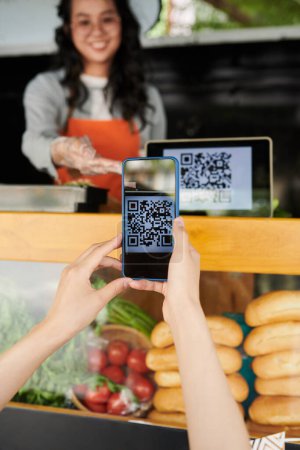 Foto de El cliente escanea el código qr con el teléfono inteligente para leer el menú o pagar por orden - Imagen libre de derechos