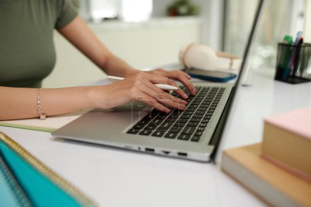 Téléchargez les photos : Les mains de l'étudiant travaillant sur un ordinateur portable au bureau à la maison - en image libre de droit