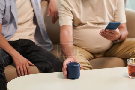 Photo for Cropped image of turning on speaker to listen to music with his grandson - Royalty Free Image
