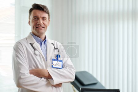 Photo for Portrait of smiling experienced plastic surgeon crossing arms and looking at camera - Royalty Free Image