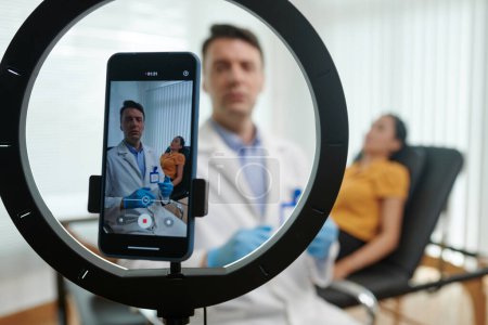 Foto de Doctor streaming de sí mismo consultando paciente antes de la cirugía - Imagen libre de derechos