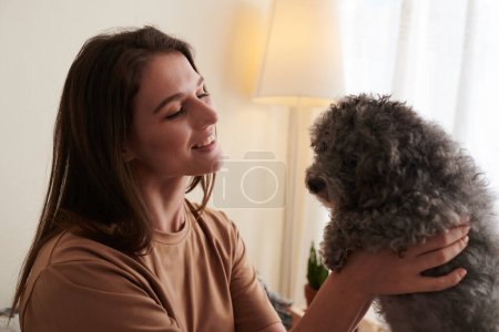 Photo for Happy woman interacting with dog, that helps relieve stresss, anxiety and calms emotional wellbeing - Royalty Free Image