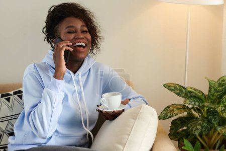 Téléchargez les photos : Portrait de jeune femme noire riant en parlant au téléphone avec le meilleur ami - en image libre de droit